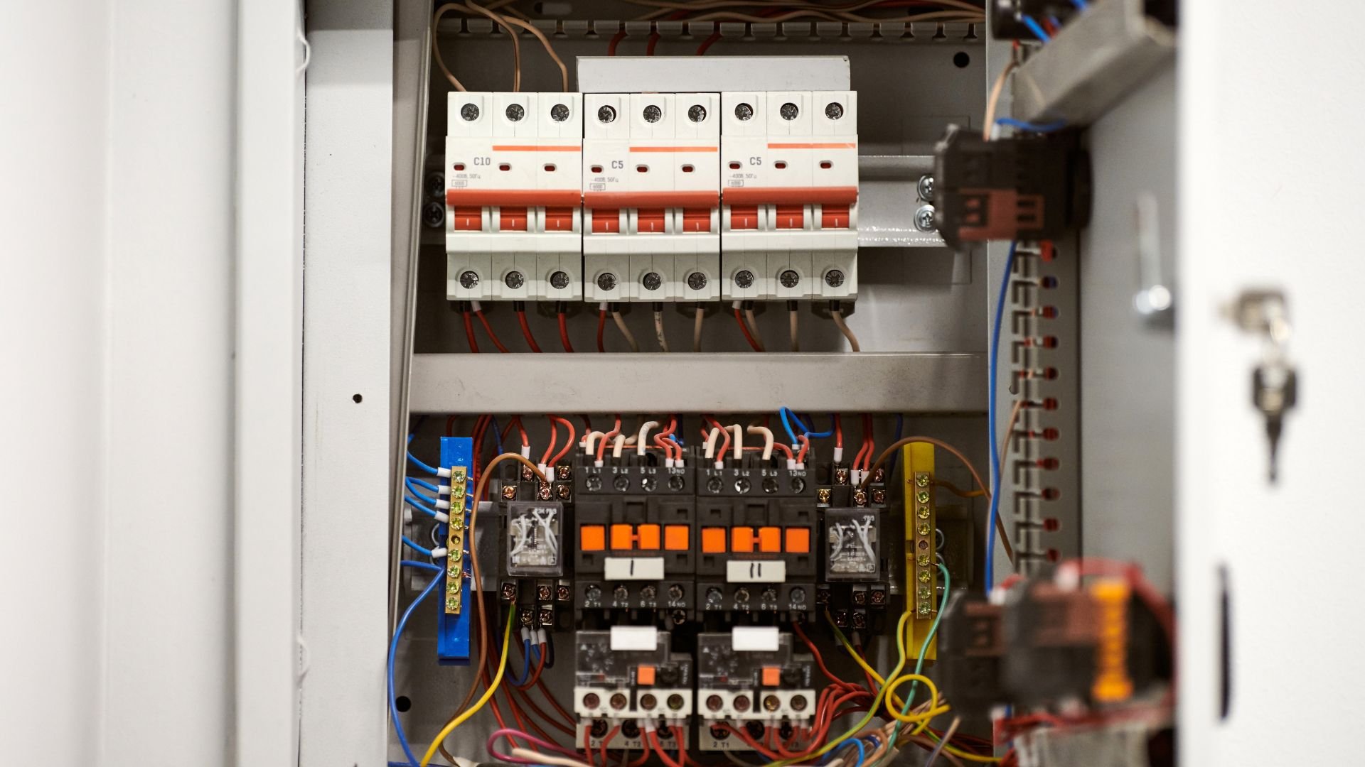 Electrical circuit breaker panel with multiple switches and colored wires