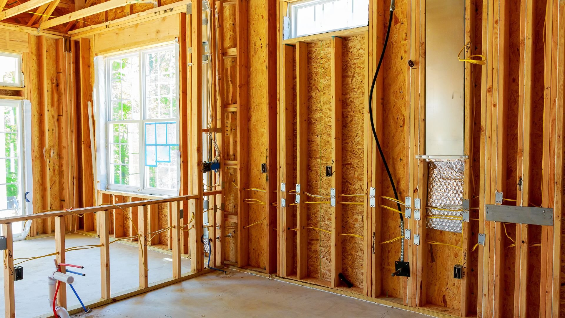 Interior of wood-framed house under construction with exposed electrical wiring